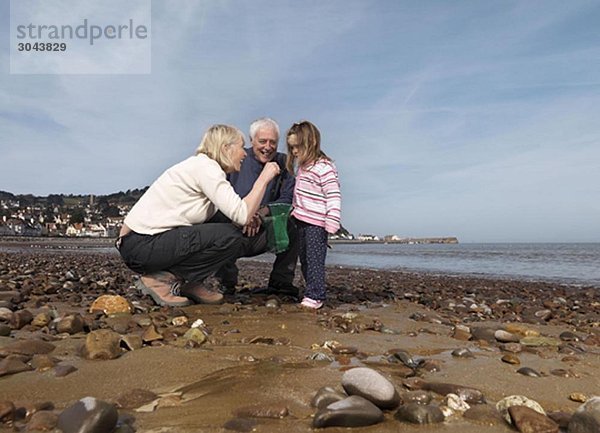 reifes Paar mit Kind am Strand