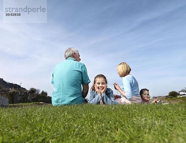 reifes Paar & Kinder entspannen sich auf Rasen