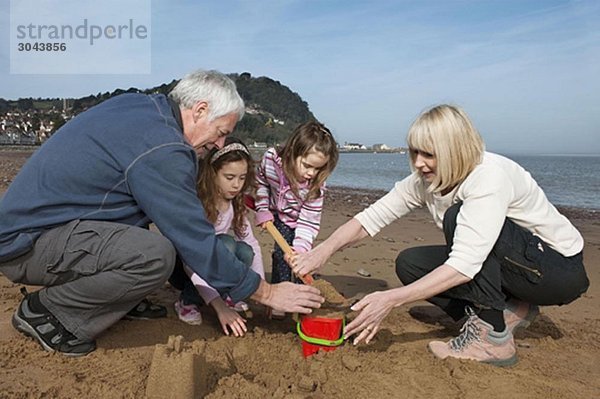 reifes Paar mit Kindern am Strand