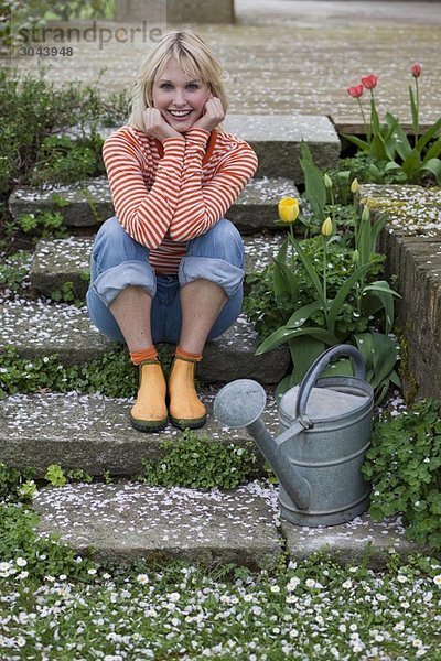 Frau auf der Gartentreppe sitzend