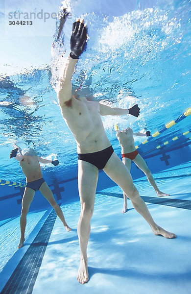 Männer trainieren im Schwimmbad.