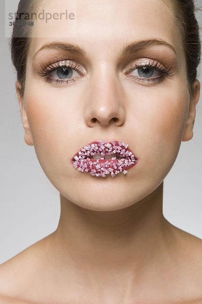 weibliche Schönheit mit Süßigkeiten auf den Lippen  im Mund