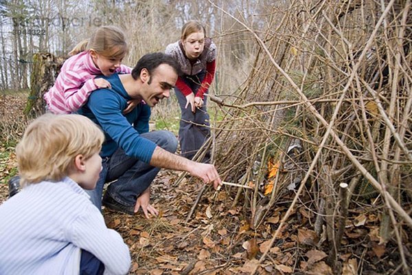 Junge  Mädchen  Mann beim Anzünden von Lagerfeuer