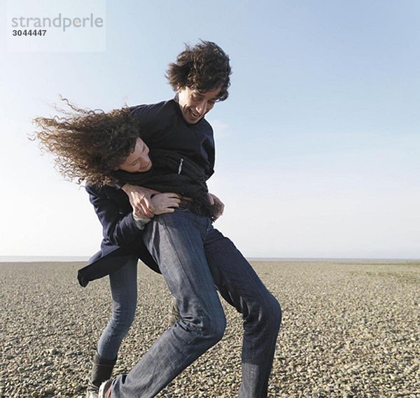 Pärchen spielen am Strand