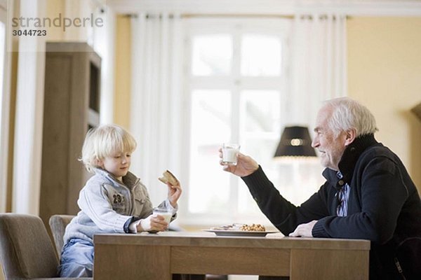 Enkel und Großvater beim Essen