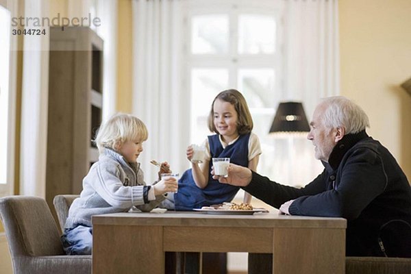 Großvater und Enkelkinder beim Essen
