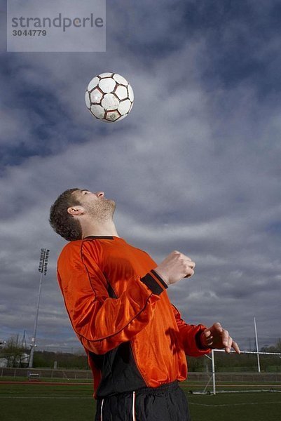 Fußballspieler  der einen Ball zu sich selbst führt.