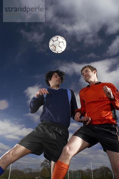 zwei Fußballspieler springen für den Fußball