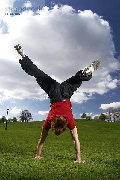 Mann mit Handstand im Park