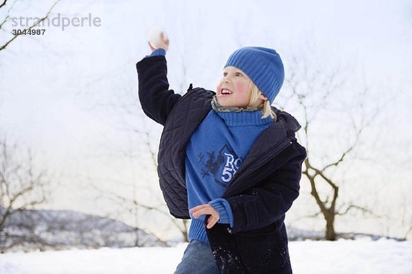 Skandinavischer Junge wirft Schneeball