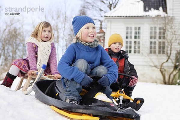 Skandinavische Kinder auf Schlitten