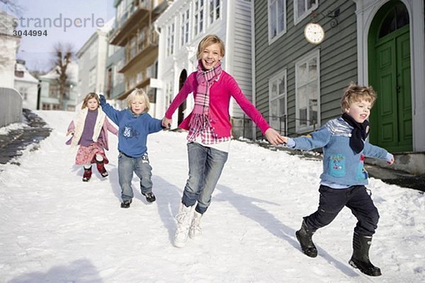 Skandinavische Kinder beim Laufen im Schnee