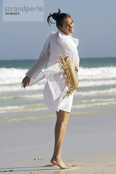 Junge Frau zu Fuß am Strand