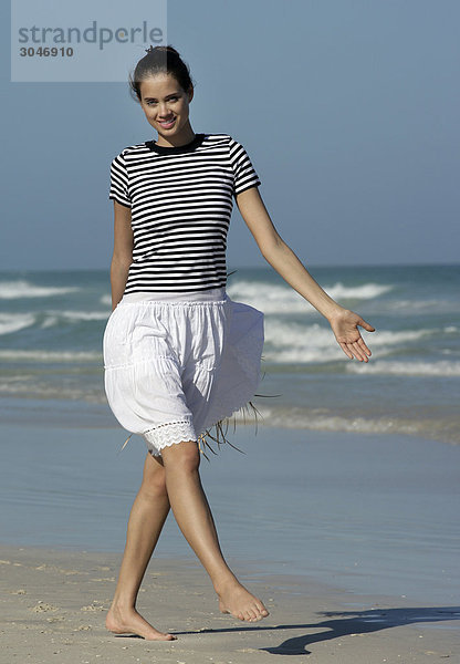 Junge Frau zu Fuß am Strand