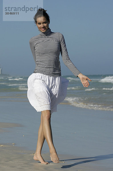 Junge Frau zu Fuß am Strand