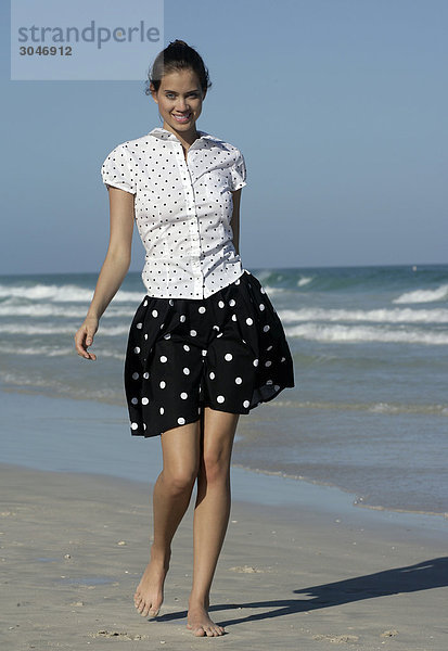 Junge Frau zu Fuß am Strand