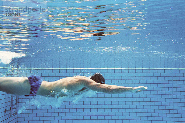 Mann schwimmt unter Wasser  Seitenansicht