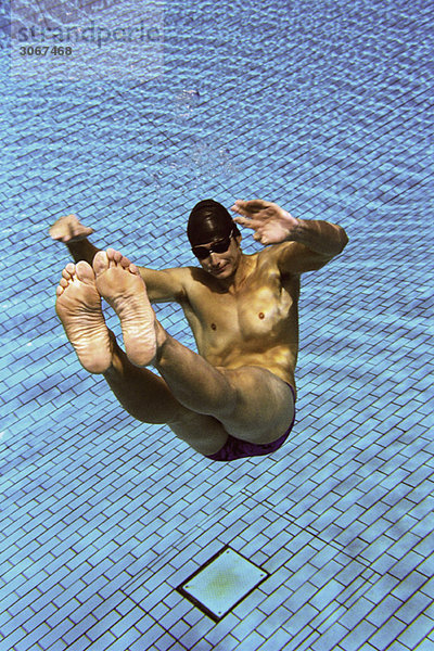 Männlicher Schwimmer schwimmend unter Wasser im Schwimmbad