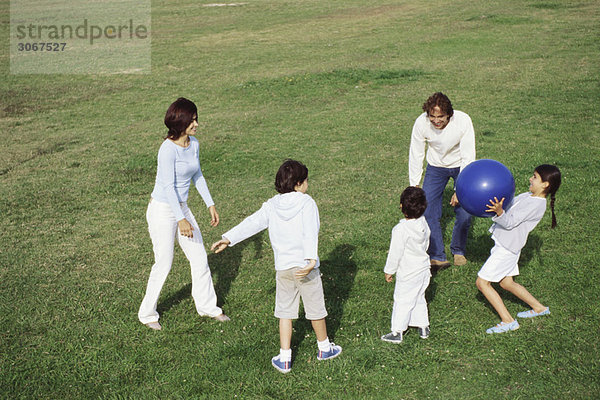 Familienspiel mit Ball im Grasfeld