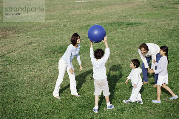 Familienspiel mit Ball im Grasfeld