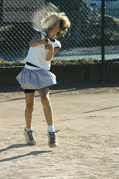 Kleines Mädchen beim Tennisspielen
