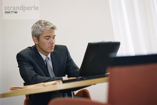 Geschäftsmann bei der Arbeit am Laptop