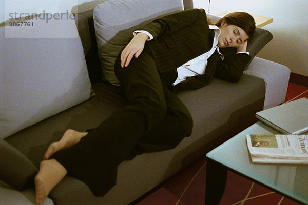 Geschäftsfrau voll bekleidet schlafend auf Sofa