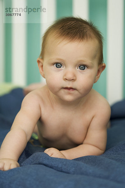 Baby auf dem Bauch liegend  mit Blick auf die Kamera  Porträt