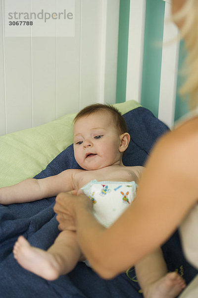 Frau beim Wickeln von Babywindeln