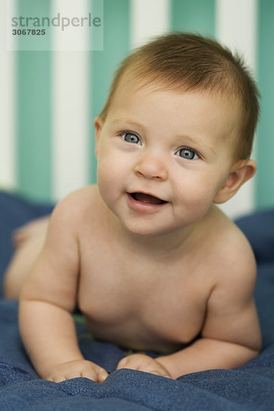 Baby auf dem Bauch liegend  lächelnd  Portrait
