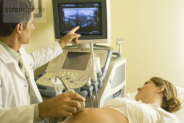 Arzt  der Ultraschall an einer schwangeren Frau durchführt