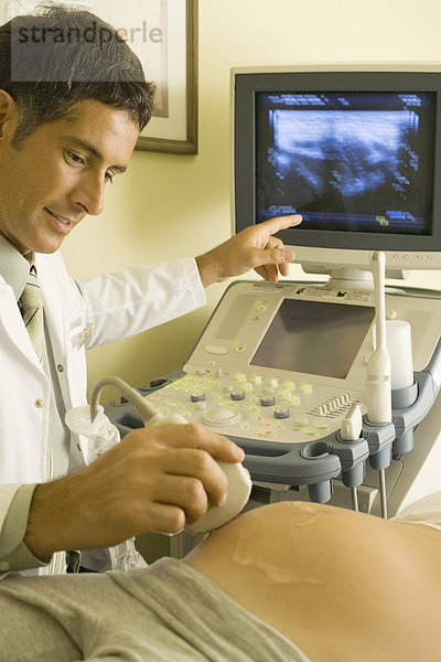 Arzt  der Ultraschall an einer schwangeren Frau durchführt  abgeschnitten