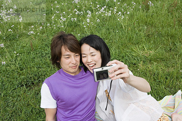 Junges Paar auf dem Feld mit Kamera