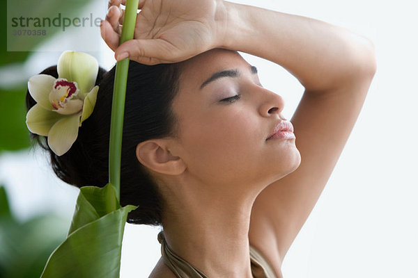 Junge Frau mit Blatt und Blume im Haar