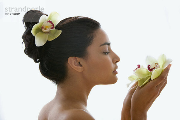 Junge Frau mit einer Orchideenblüte