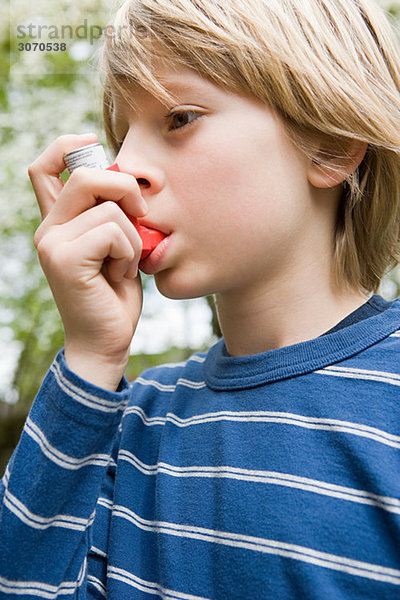 Junge nimmt Asthma-Inhalator