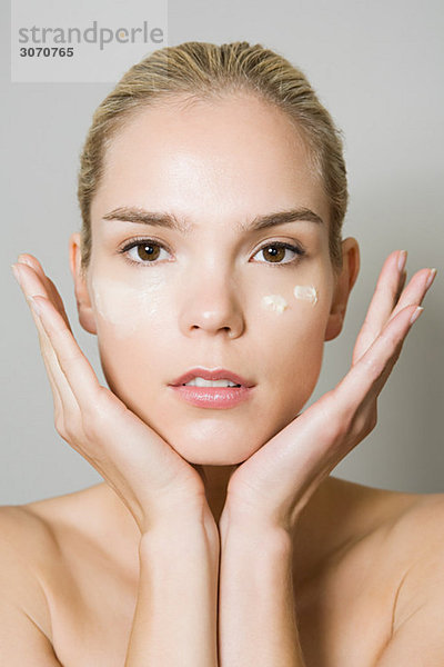 Junge Frau mit Feuchtigkeitscreme im Gesicht