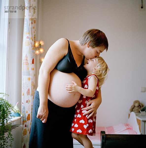 Frau küssen Schwangerschaft Tochter