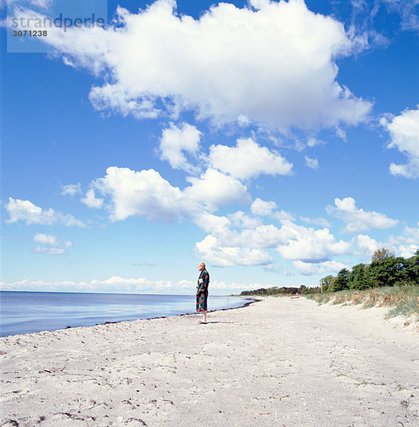 Ein Mann auf einem Strand Skane Schweden.