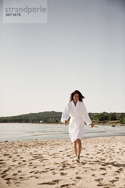 Frau an einem Strand in Bademantel Schweden gekleidet.