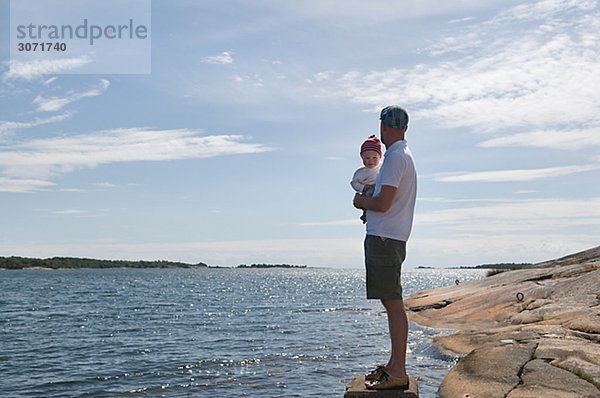 Vater mit Kindern am Meer Schweden.