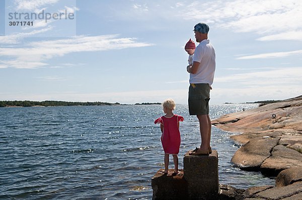 Vater mit Kindern am Meer Schweden.