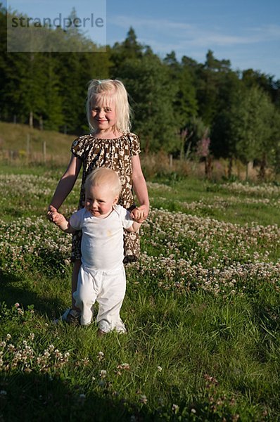 Eine Schwester und Bruder auf eine Feld-Schweden.