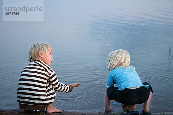 Zwei Kinder sprechen an den Wassern edge-Schweden.