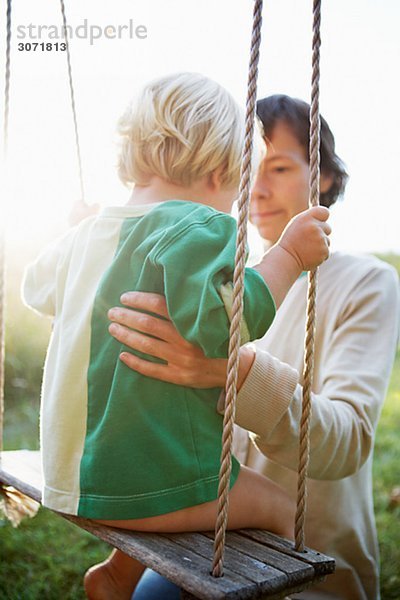 Mutter und Sun von eine Schaukel Schweden.