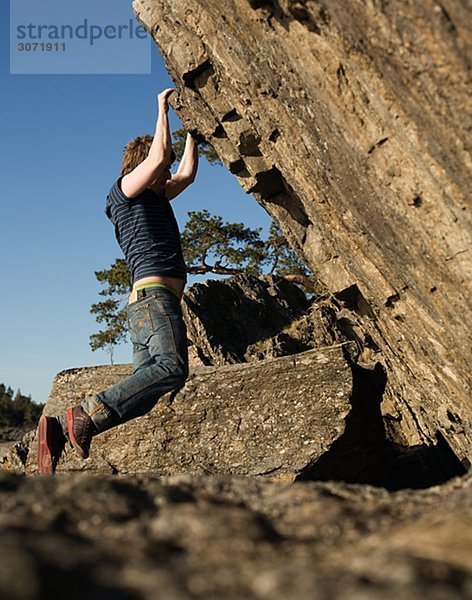Ein Mann Klettern eine Felswand Schweden.