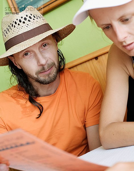 Ein Mann und eine Frau aus einem Menü auf ein Restaurant Spanien lesen.