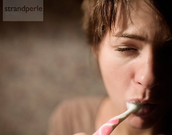Eine müde Frau putzen ihre Zähne Schweden.