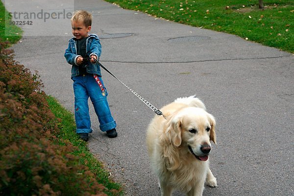 Ein Junge zu Fuß mit einen Hund Linköping-Schweden