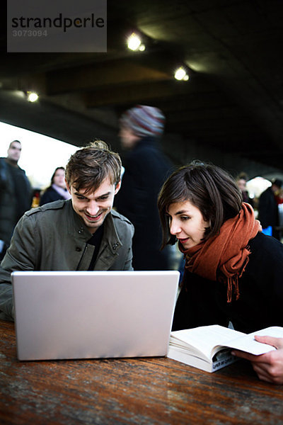 A couple in London using a laptop Great Britain.